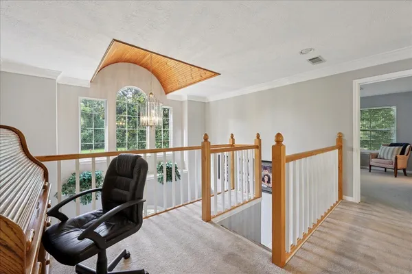 a view of a livingroom with furniture staircase and windows