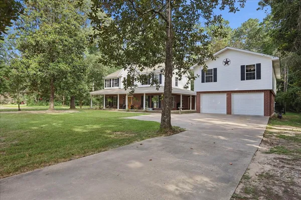 a front view of a house with a garden and trees