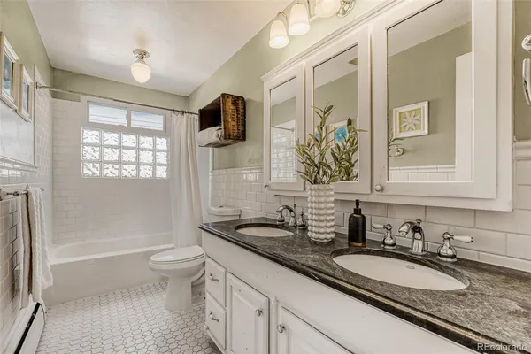 a bathroom with a granite countertop double vanity sink a mirror and a
