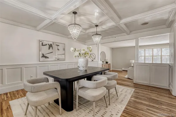 a dining room with wooden floor a chandelier a wooden table and chairs