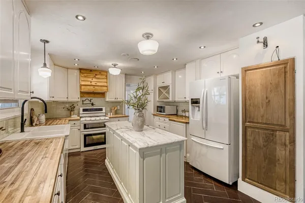 a kitchen with stainless steel appliances granite countertop a refrigerator and a stove top oven