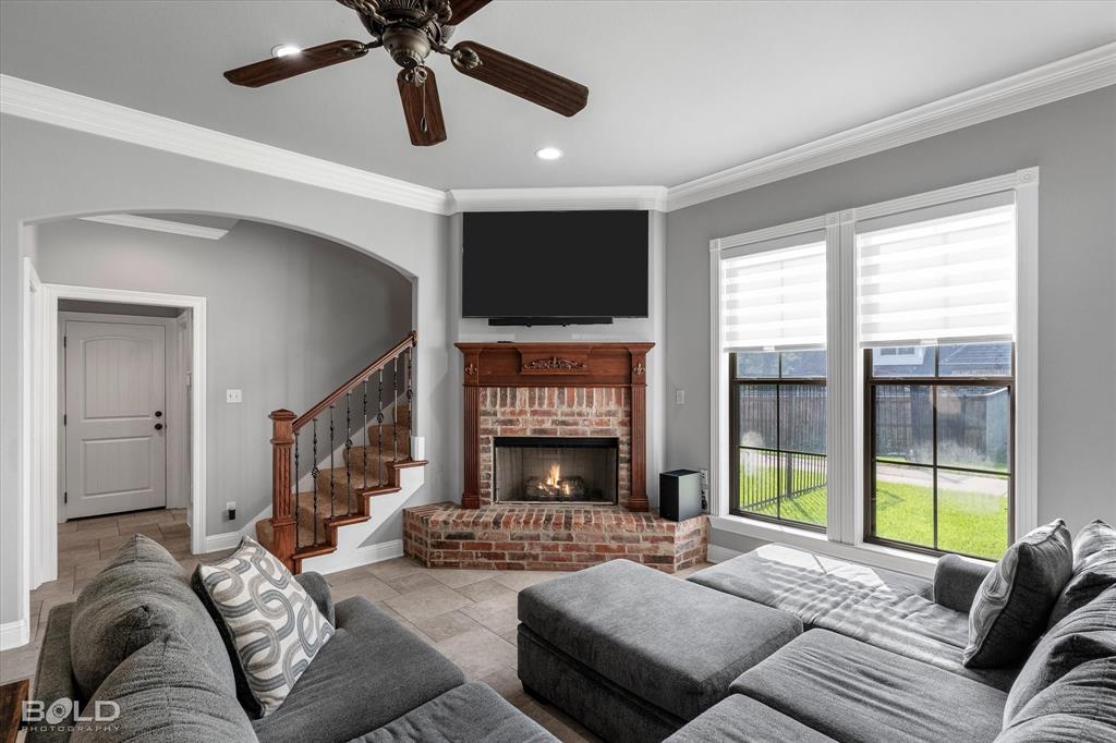 2220 Forest Hills Boulevard Haughton, LA 71037 - Photo 19 of 40 Corner brick fireplace with a wood mantle, accented by natural light from two large windows