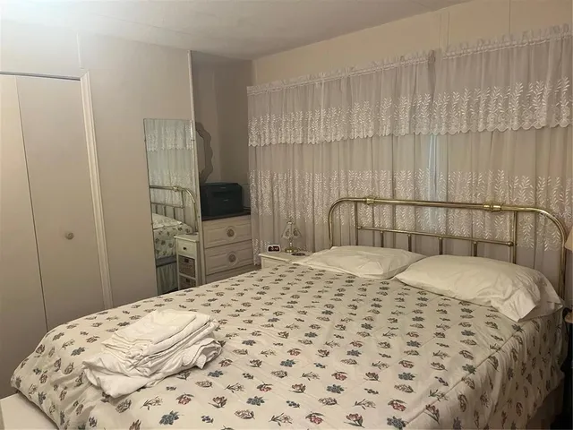 a bedroom with a bed and a flat tv screen