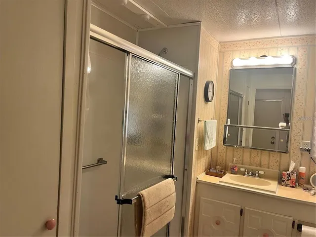 a bathroom with a mirror sink and glass door shower