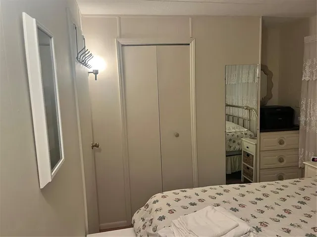 a bedroom with a bed and a flat tv screen in it