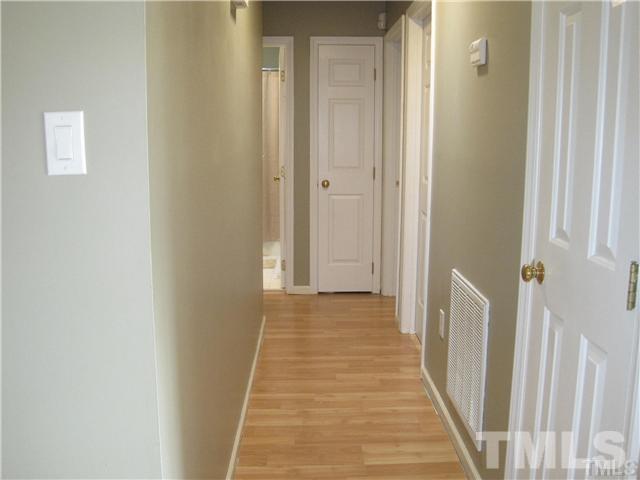 4505 Cobbler Place Raleigh, NC 27613 - Photo 5 of 13 a view of a hallway with wooden floor and a bathroom
