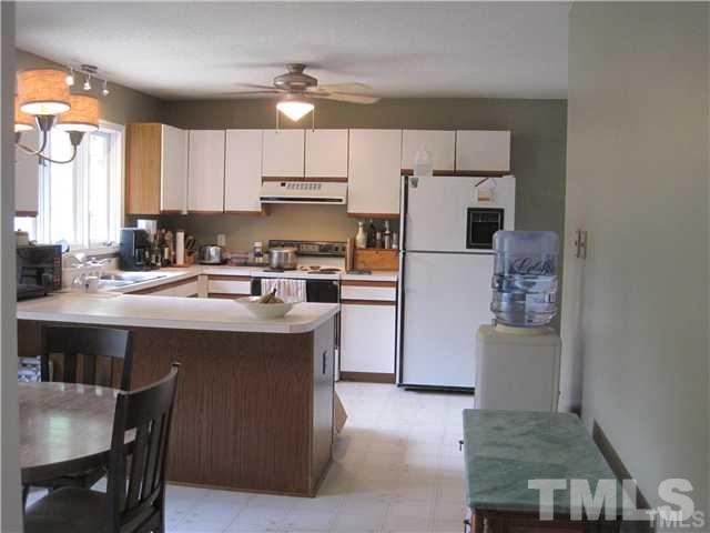4505 Cobbler Place Raleigh, NC 27613 - Photo 8 of 13 a kitchen with a sink a refrigerator and chairs