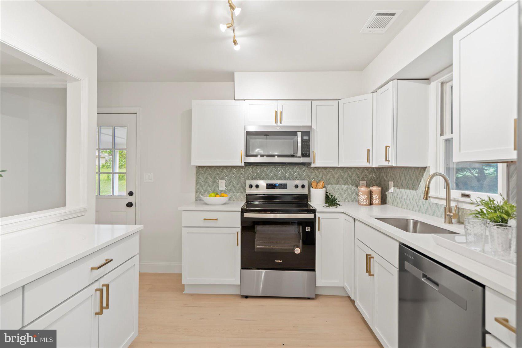 4566 Hickory Lane Mount Airy, MD 21771 - Photo 22 of 45 a kitchen with a sink white cabinets and stainless steel appliances
