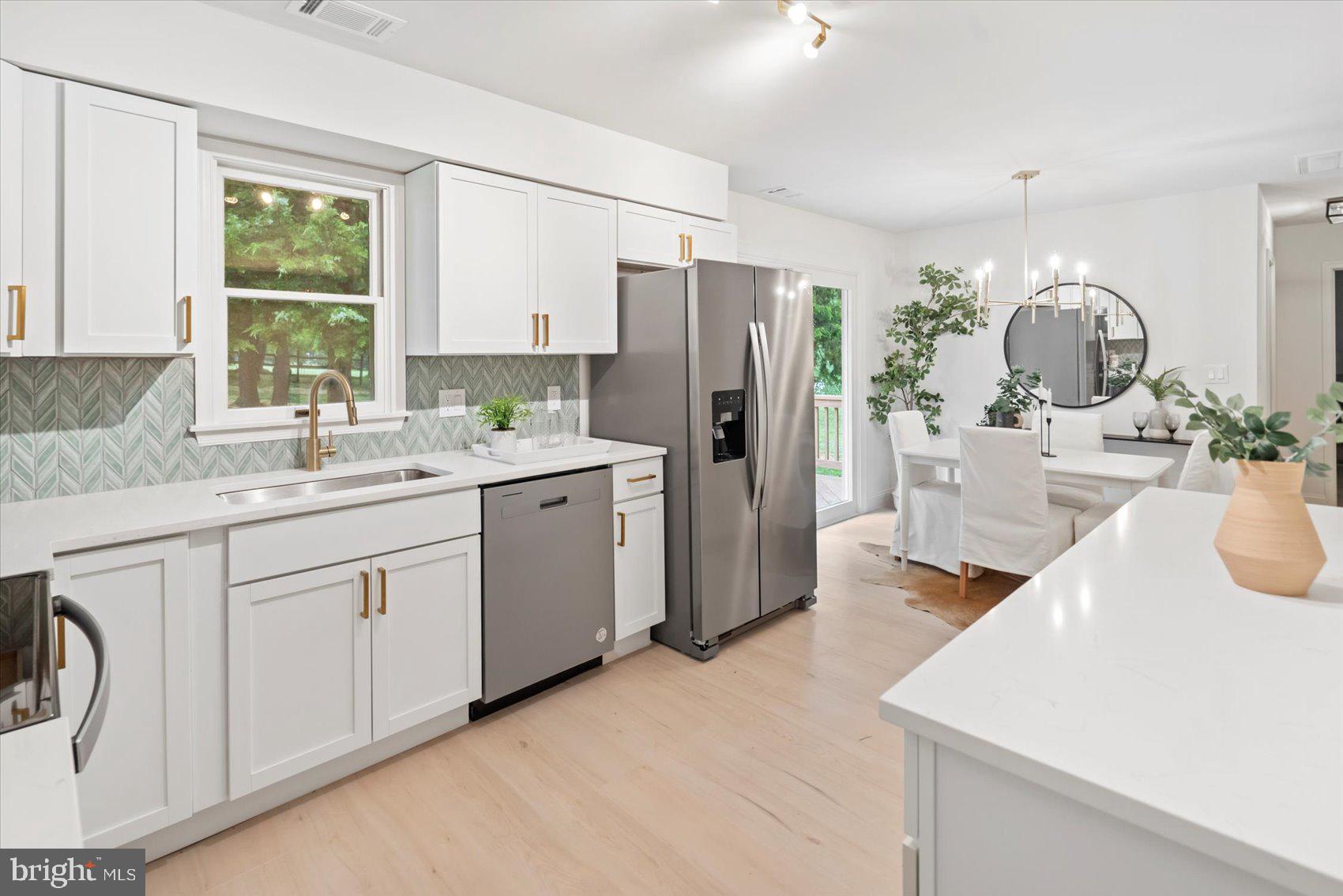 4566 Hickory Lane Mount Airy, MD 21771 - Photo 23 of 45 a kitchen with a sink dishwasher a refrigerator and cabinets