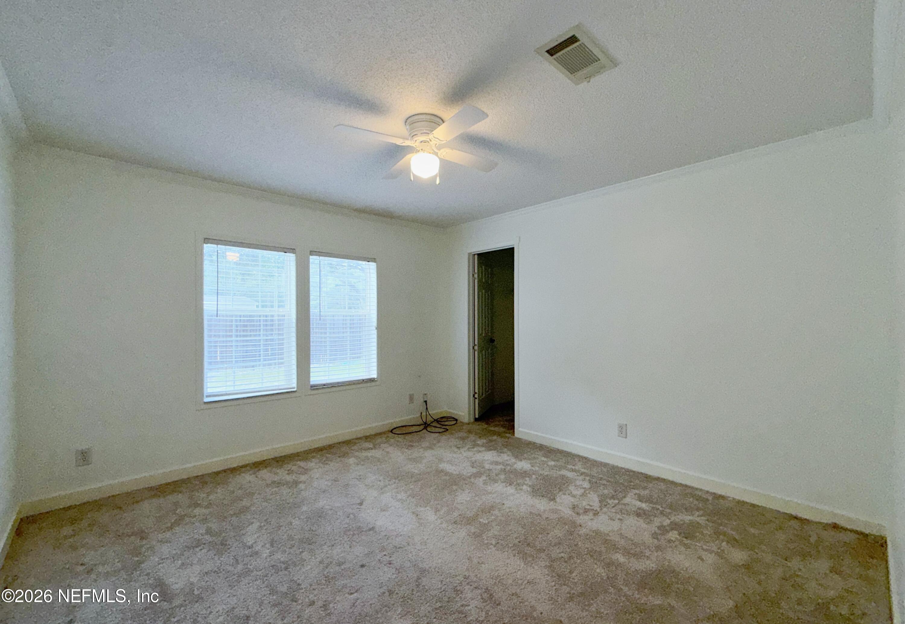 136 Short Pine Road Hawthorne, FL 32640 - Photo 22 of 39 an empty room with chandelier fan and windows