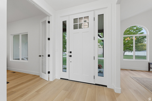 702 Alpine Highway Alpine, UT 84004 - Photo 17 of 83 Entryway with wood-finish flooring, a white paneled front door with glass inserts, and two clear glass sidelights