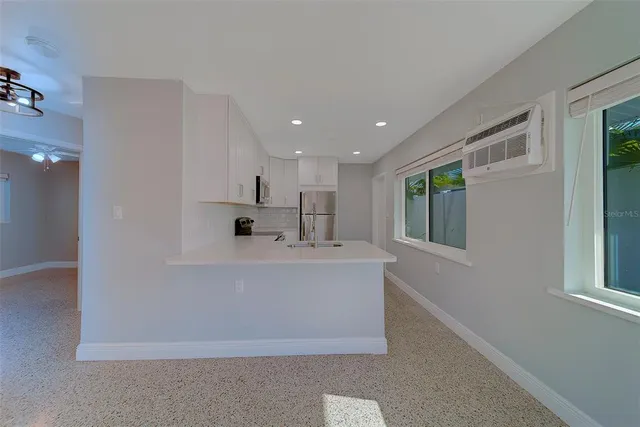 a kitchen with stainless steel appliances a refrigerator sink and microwave