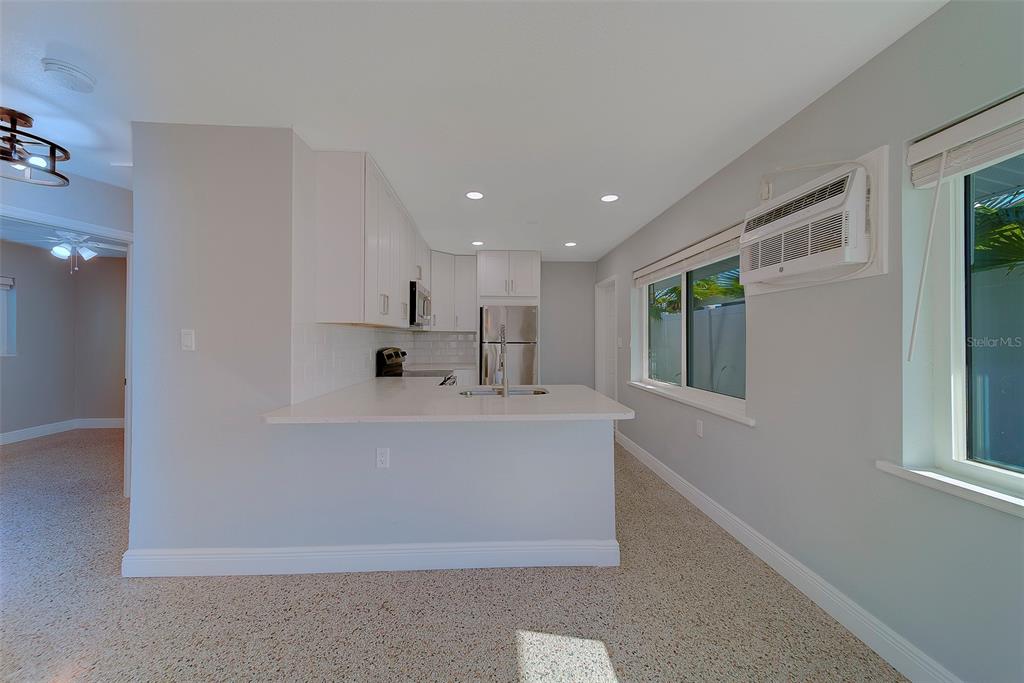 13248 4th Street East, Unit B Madeira Beach, FL 33708 - Photo 12 of 49 a view of kitchen with stainless steel appliances granite countertop a refrigerator a sink a stove and a refrigerator with wooden floor