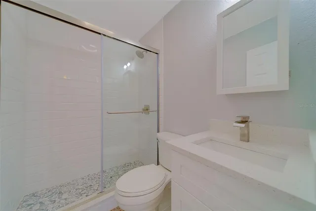 a bathroom with a shower a toilet and sink