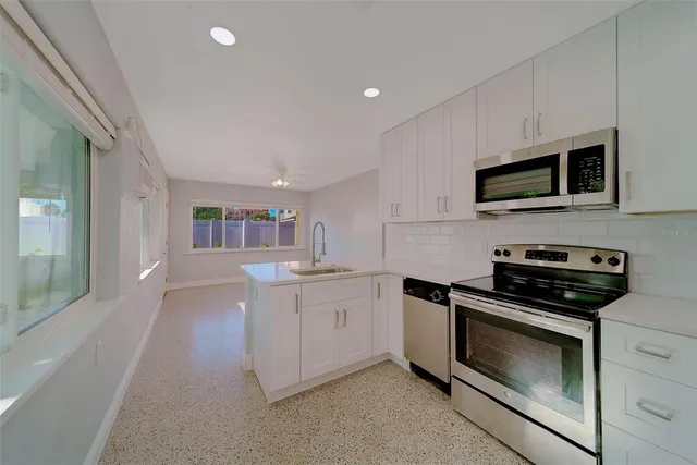 a kitchen with white cabinets and stainless steel appliances