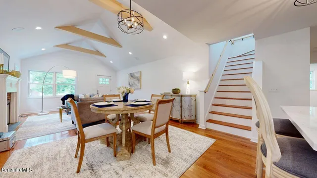 a view of a dining room and livingroom with furniture wooden floor and a rug