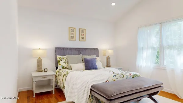 a bedroom with a bed and wooden floor