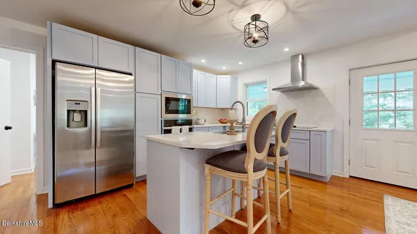 a kitchen with granite countertop stainless steel appliances a refrigerator a stove a sink cabinets and dining table