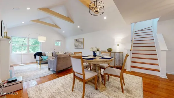a dining room with furniture a rug and wooden floor