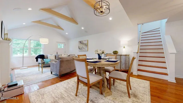 a dining room with furniture a rug and wooden floor