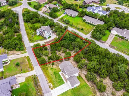 an aerial view of a residential houses with yard
