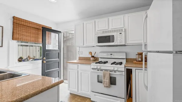 a kitchen with stainless steel appliances white cabinets and a stove top oven