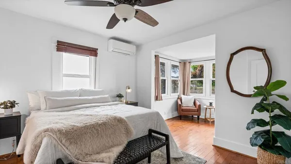 a bedroom with a bed lamps and a large mirror