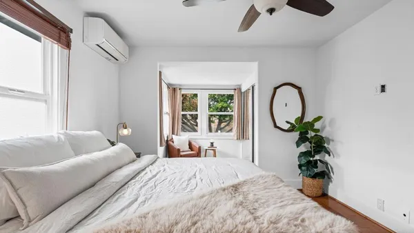 a bed room with a bed mirror and a window