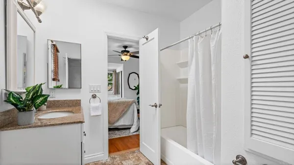 a bathroom with a granite countertop sink a mirror a vanity and a shower