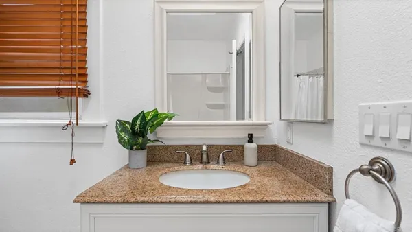a bathroom with a granite countertop sink and a mirror