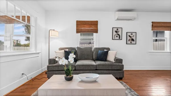 a living room with furniture and wooden floor