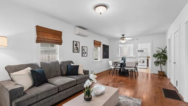 a living room with furniture wooden floor and a window