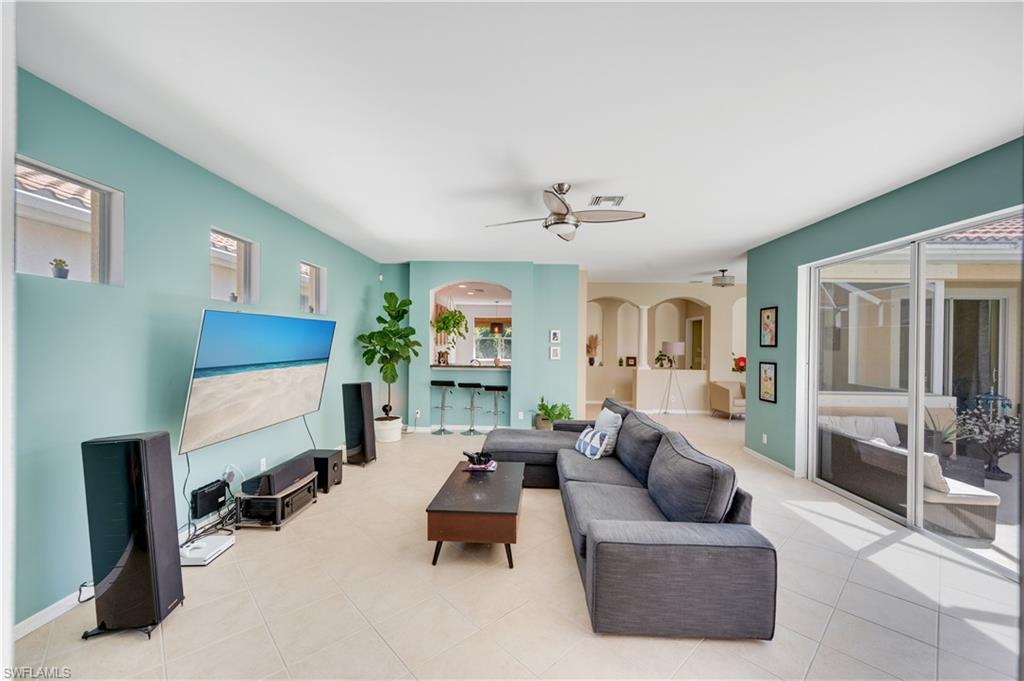 5738 Lago Villaggio Way Naples, FL 34104 - Photo 13 of 28 a living room with furniture and a lamp