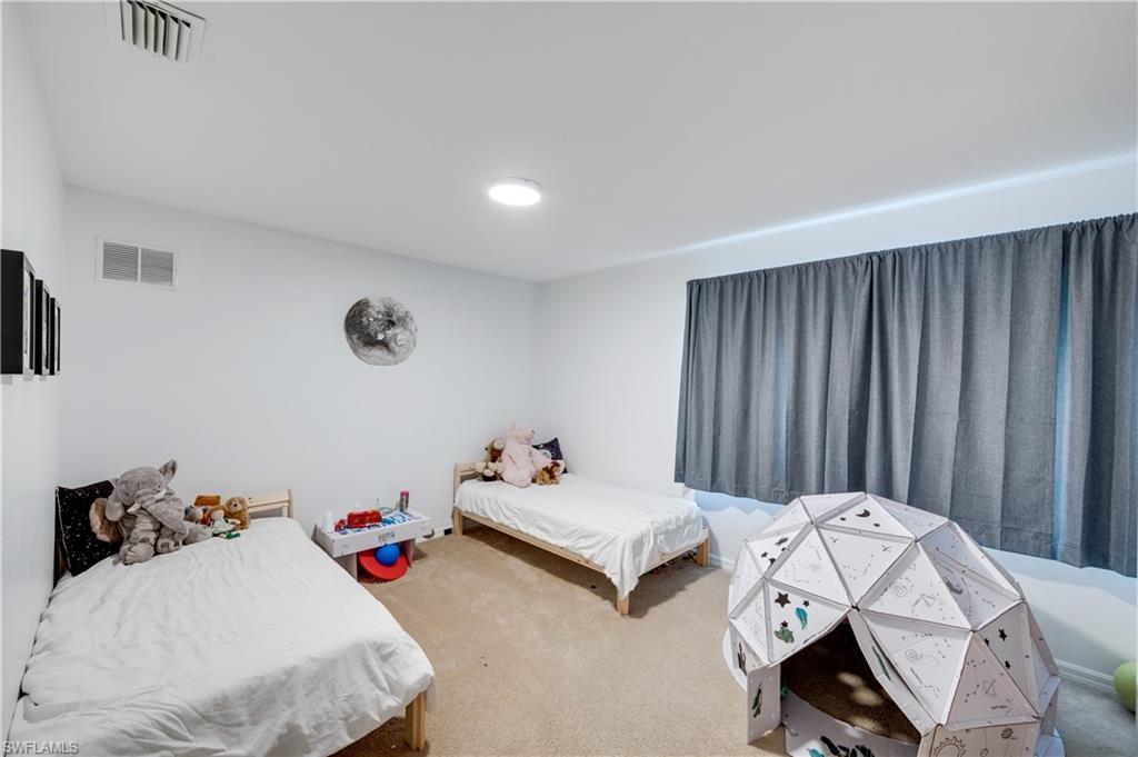 5738 Lago Villaggio Way Naples, FL 34104 - Photo 17 of 28 a bedroom with bed and window