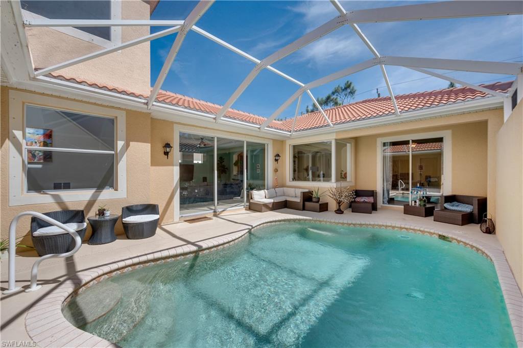5738 Lago Villaggio Way Naples, FL 34104 - Photo 19 of 28 a view of a backyard with table and chairs and potted plants