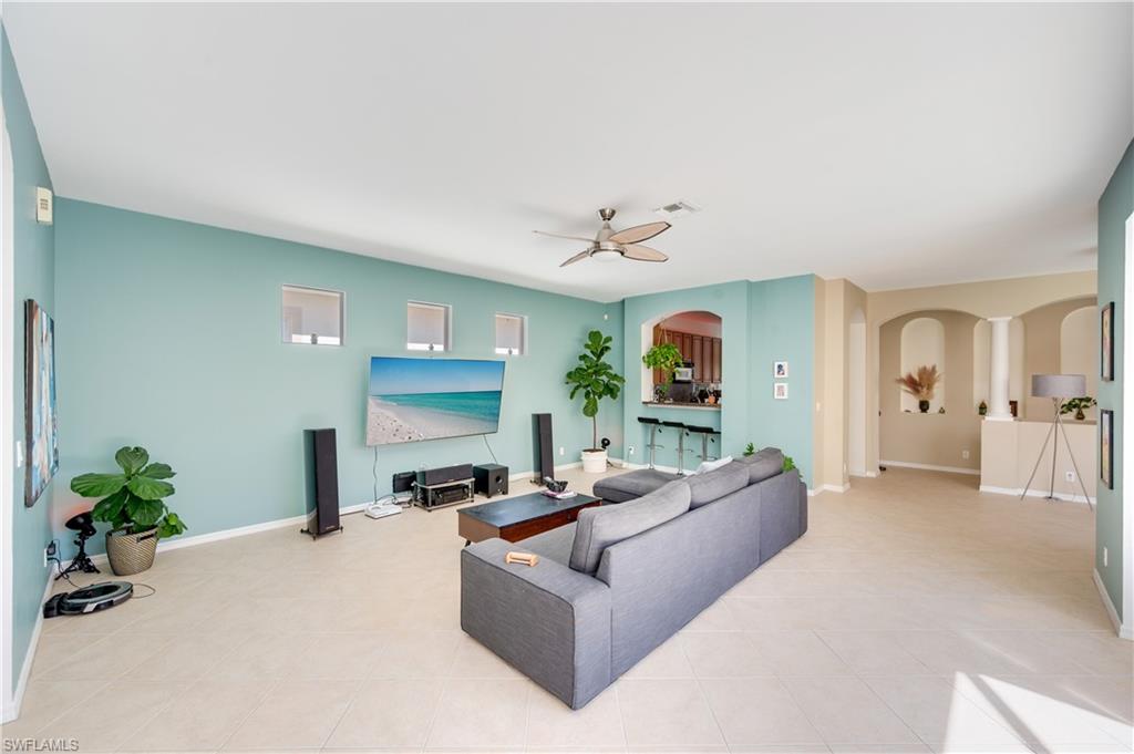 5738 Lago Villaggio Way Naples, FL 34104 - Photo 2 of 28 a living room with furniture and a chandelier