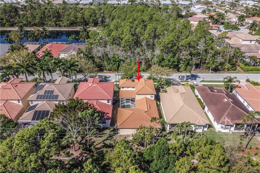 5738 Lago Villaggio Way Naples, FL 34104 - Photo 26 of 28 an aerial view of a house with a yard and lake