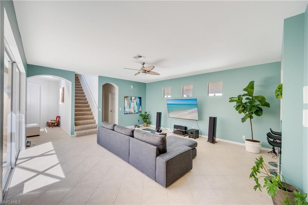 5738 Lago Villaggio Way Naples, FL 34104 - Photo 4 of 28 a living room with furniture and a chandelier