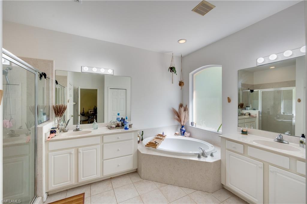 5738 Lago Villaggio Way Naples, FL 34104 - Photo 8 of 28 a bathroom with a tub a sink double and mirror