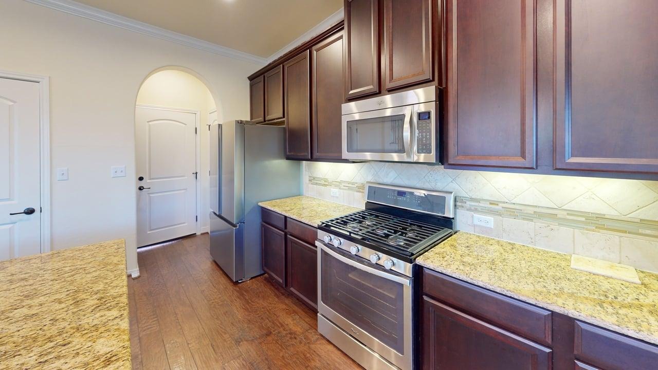 12004 Terraza Circle, Unit TH32 Austin, TX 78726 - Photo 2 of 25 a kitchen with stainless steel appliances granite countertop a stove a sink and a refrigerator