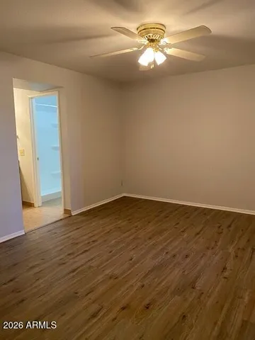 a view of a room with wooden floor and a ceiling fan