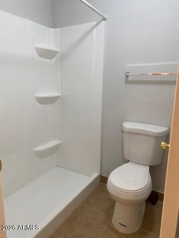 a white toilet sitting next to a shower