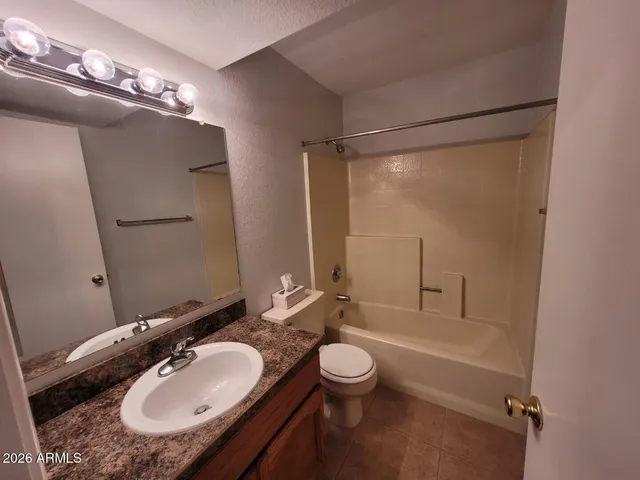 a bathroom with a granite countertop sink toilet a mirror a vanity and shower
