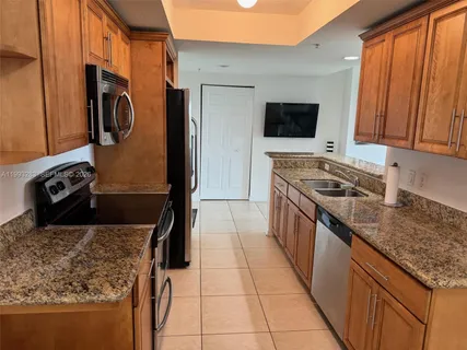 a kitchen with stainless steel appliances granite countertop a stove top oven microwave and refrigerator