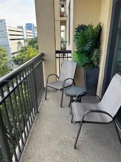 a balcony with chairs and potted plants