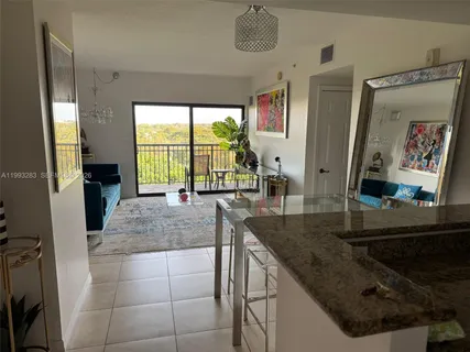 a kitchen with a sink a counter top space and living room view