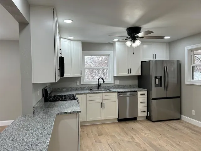 a kitchen with a refrigerator a sink and cabinets