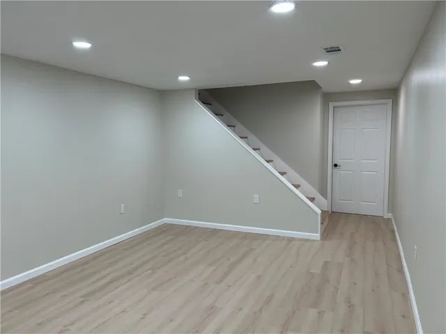 an empty room with wooden floor and white walls