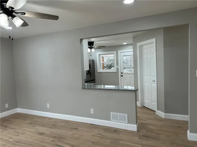 a view of a room with wooden floor and fan