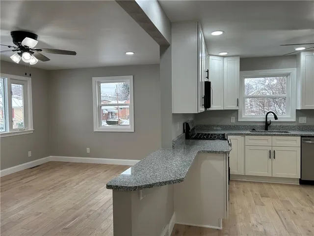 a kitchen with granite countertop cabinets stainless steel appliances a sink and a window